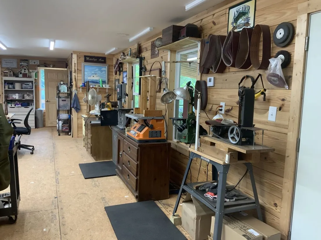 Sanding belts, a drill press and a disc sander against the shop’s pine wall